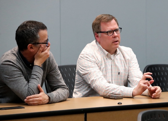 Two professors seated and speaking