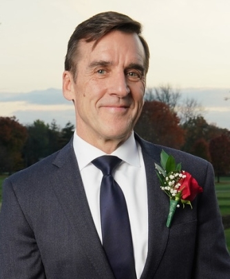 man in suit smiling with rose on lapel